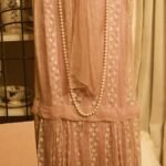 woman's dress with long strand of pearls