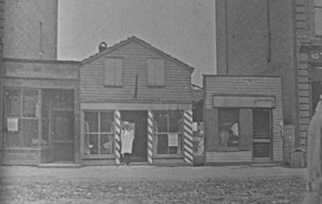 William Stewart standing in front of his barbershop.