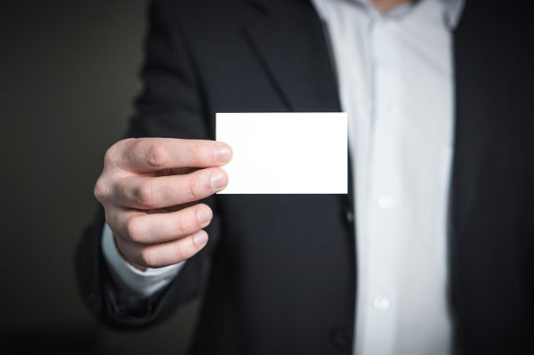 photo of man holding a blank business card